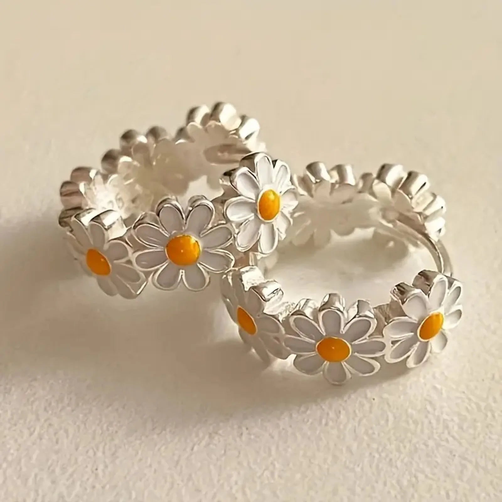 White fashion daisy flower ring earrings with electroplated finish and platinum inlay.