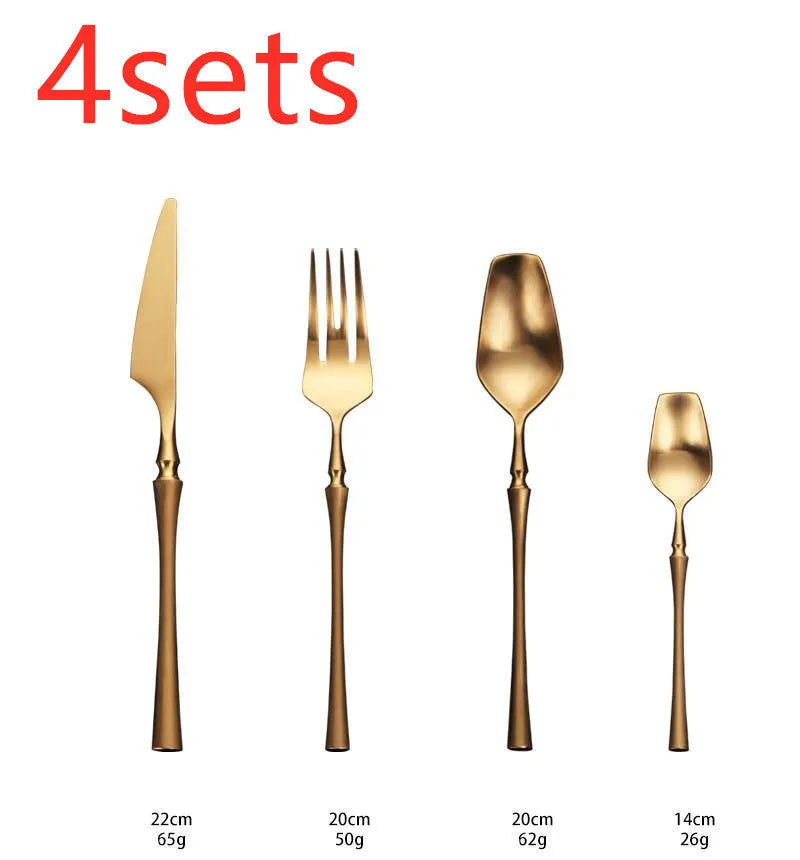 Stainless steel cutlery set with gold finish including knife, fork, spoon, and teaspoon on table
