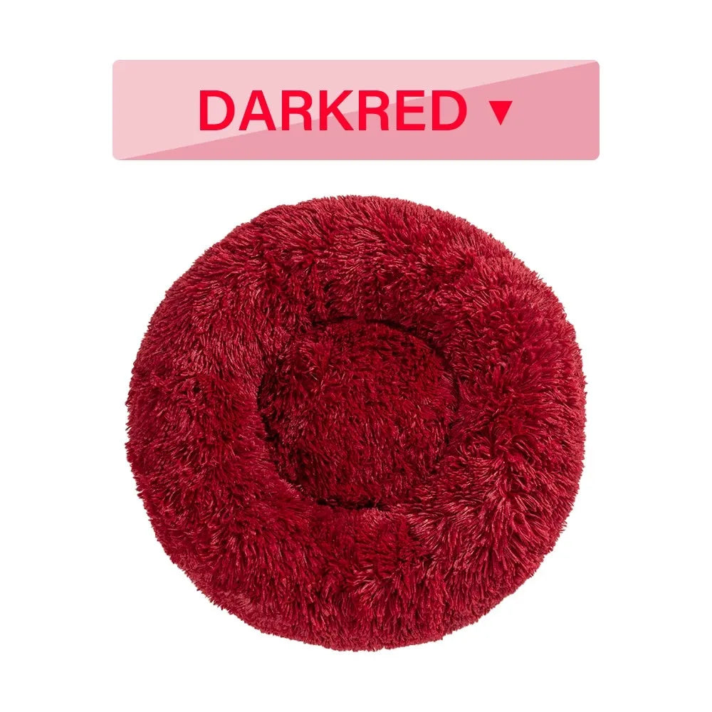 Fluffy donut-shaped dog bed in long plush fabric, shown in a light grey colour with raised edges.