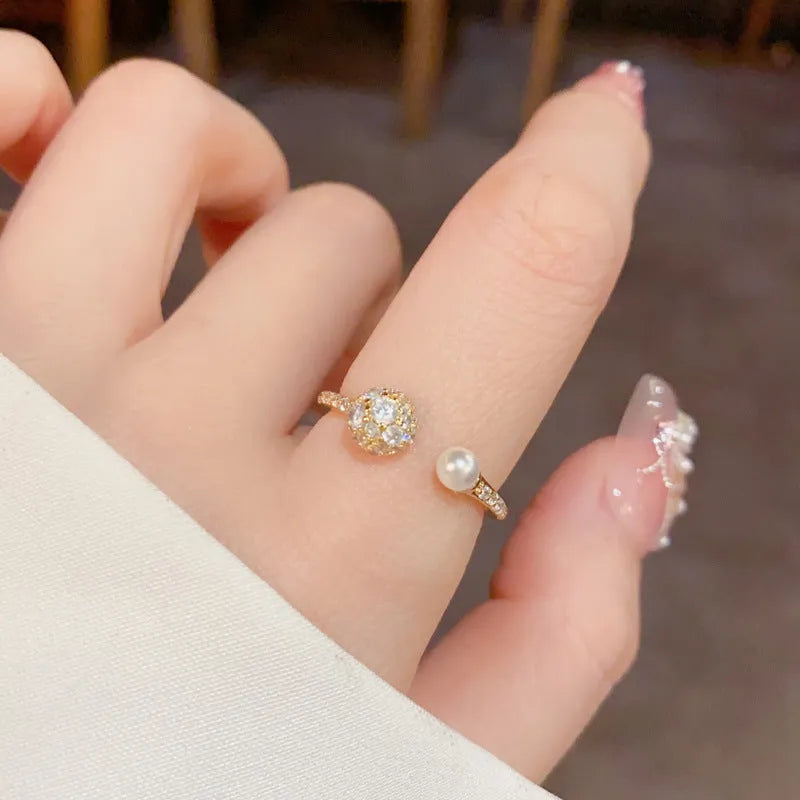 Gold or silver open-end pearl ring with round zircon detailing on a geometric band.