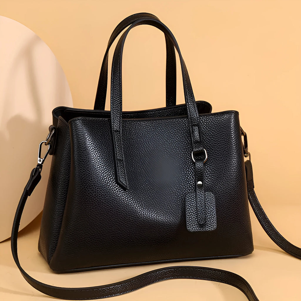 Women's cowhide leather shoulder handbag in horizontal square shape with tassel details and organised interior compartments