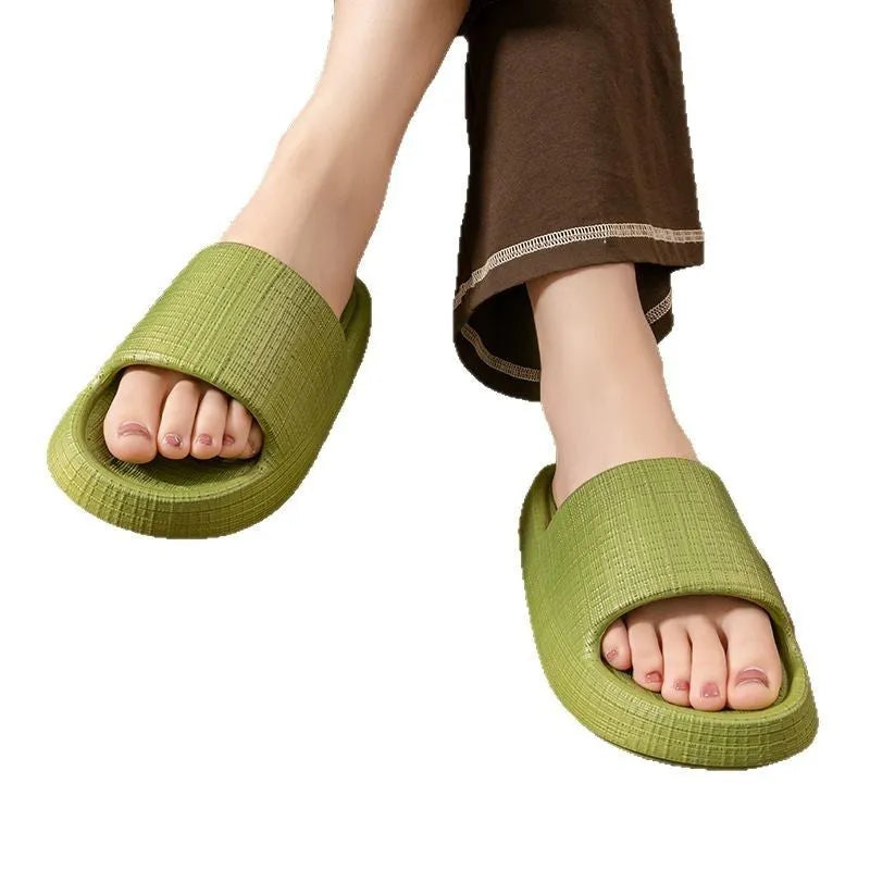 Women's soft EVA non-slip bath slipper in black, showing toe ring flip-flop design and textured sole.