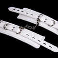 White PU sponge bondage cuffs set showing handcuffs, foot cuffs, and a neck cuff.