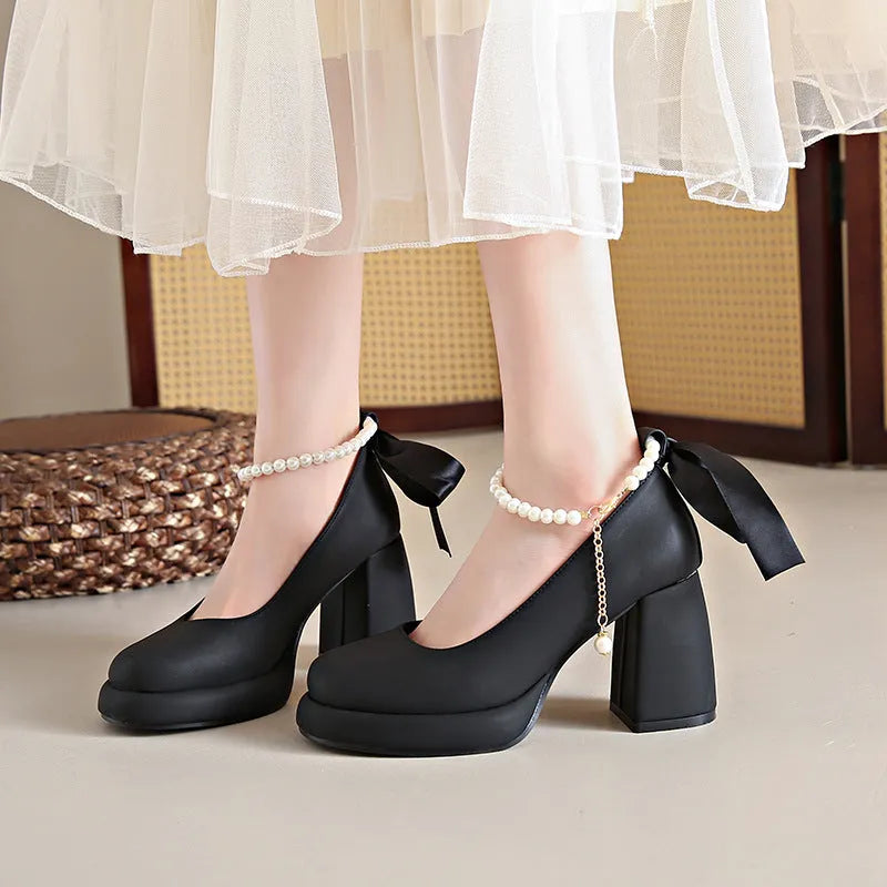 Beige women's Mary Jane shoes with chunky heel, ankle strap, pearl detail, and round toe.