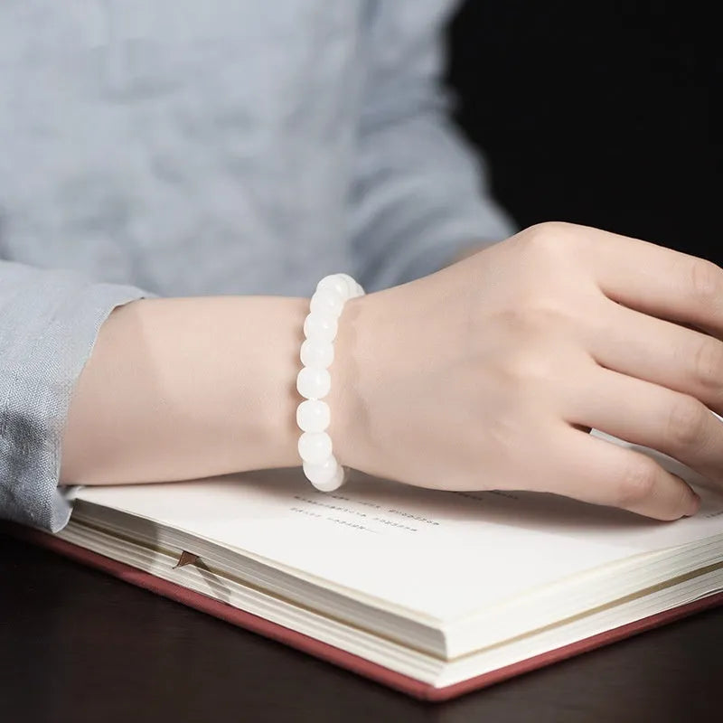 White Hetian jade barrel bead bracelet for men and women, shown in a casual style.