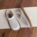 Milky white linen slip-on hole shoes with mesh lining and a light brown rubber sole, shown from the side.