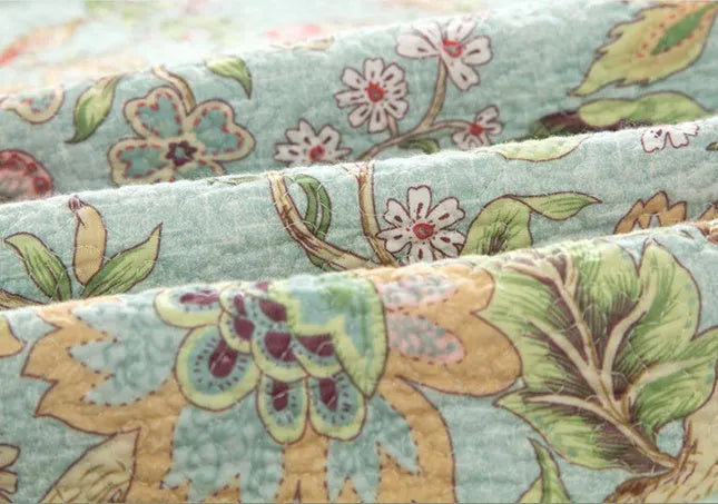 Blue cotton bedspread with American floral and bird pattern, part of a 3-piece quilt set.