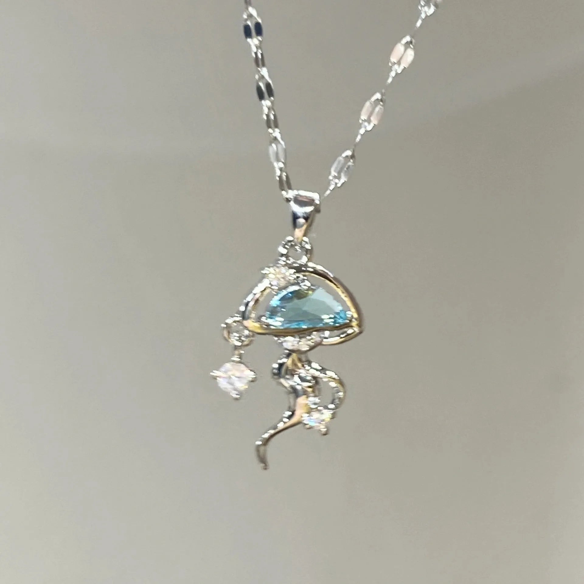Blue jellyfish pendant necklace on adjustable sterling silver chain with white gold plating