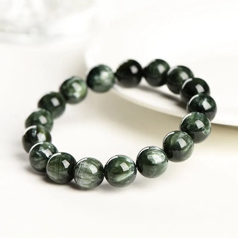 Green dragon crystal bracelet with round beads and a ruyi charm on a wrist.