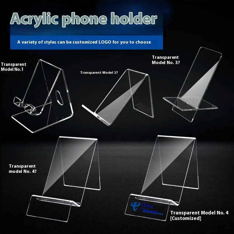 Clear acrylic mobile phone stand on a desk with a smartphone placed in it, showing the universal fit and transparent design.