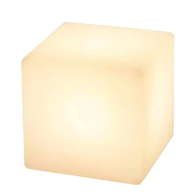 Modern square LED cube stool light outdoors, functioning as both a garden seat and a waterproof light source.