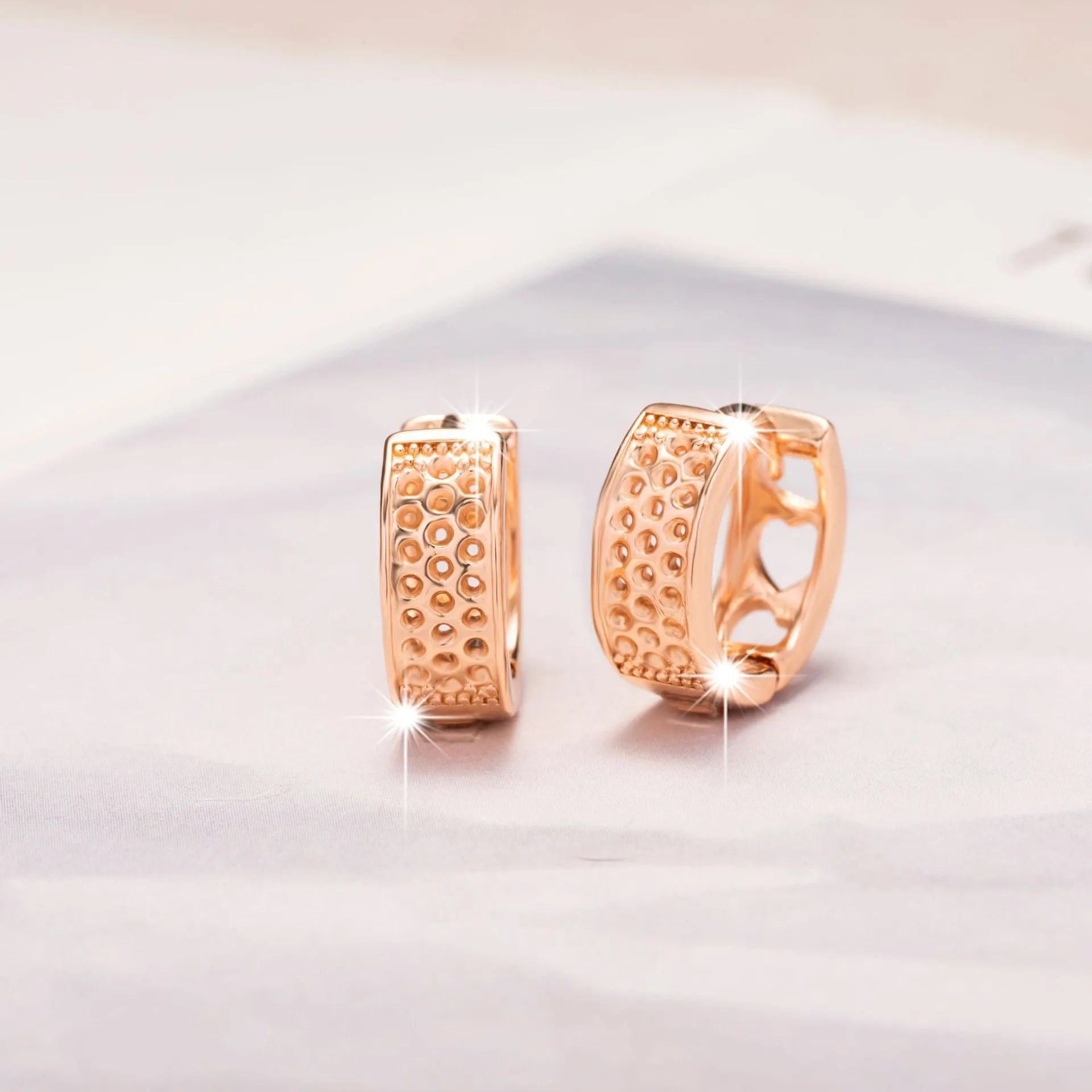 Rose gold tone women's earrings with a hollowed-out heart shape divided into three sections.