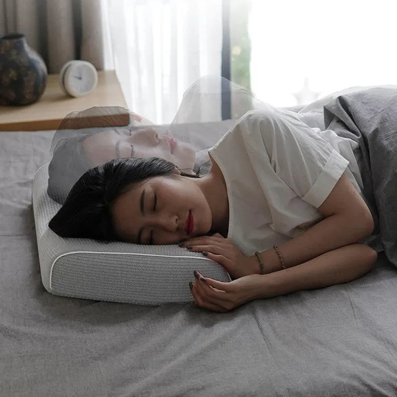 Grey memory foam massage pillow with knitted cotton cover on a bed, offering adjustable neck support for sleep