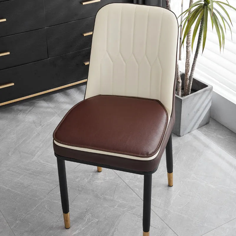 Orange leather horseshoe-shaped seat cushion with non-slip base shown on a wooden chair.