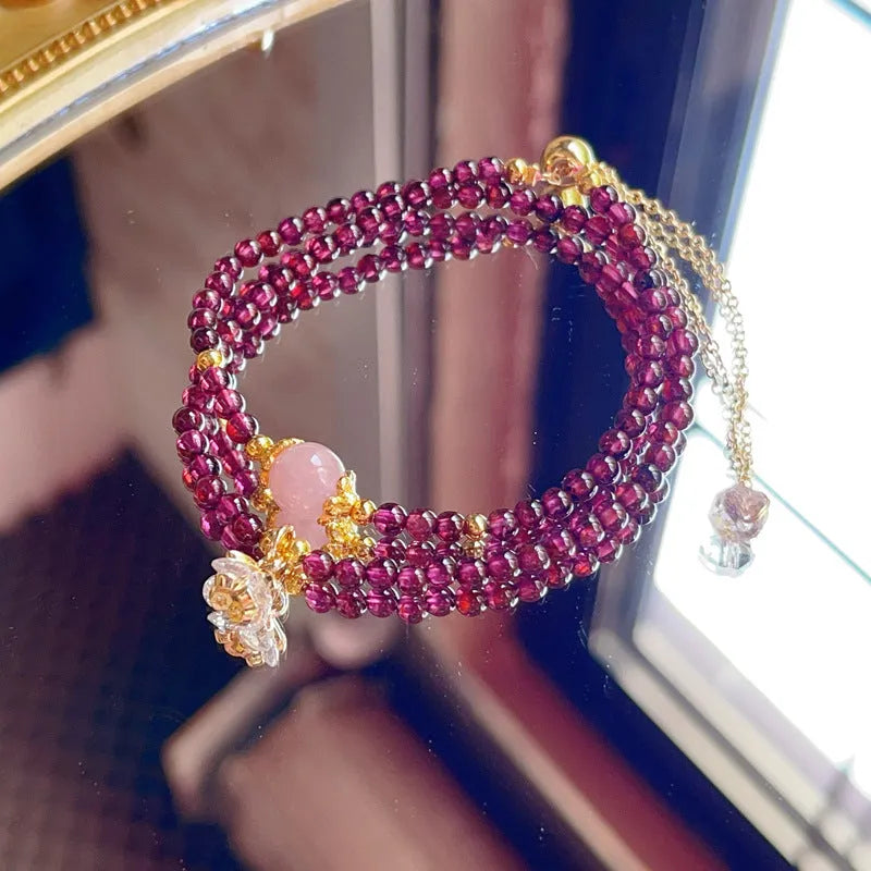 Close-up of a handmade women's natural garnet double ring bracelet in garnet colour.