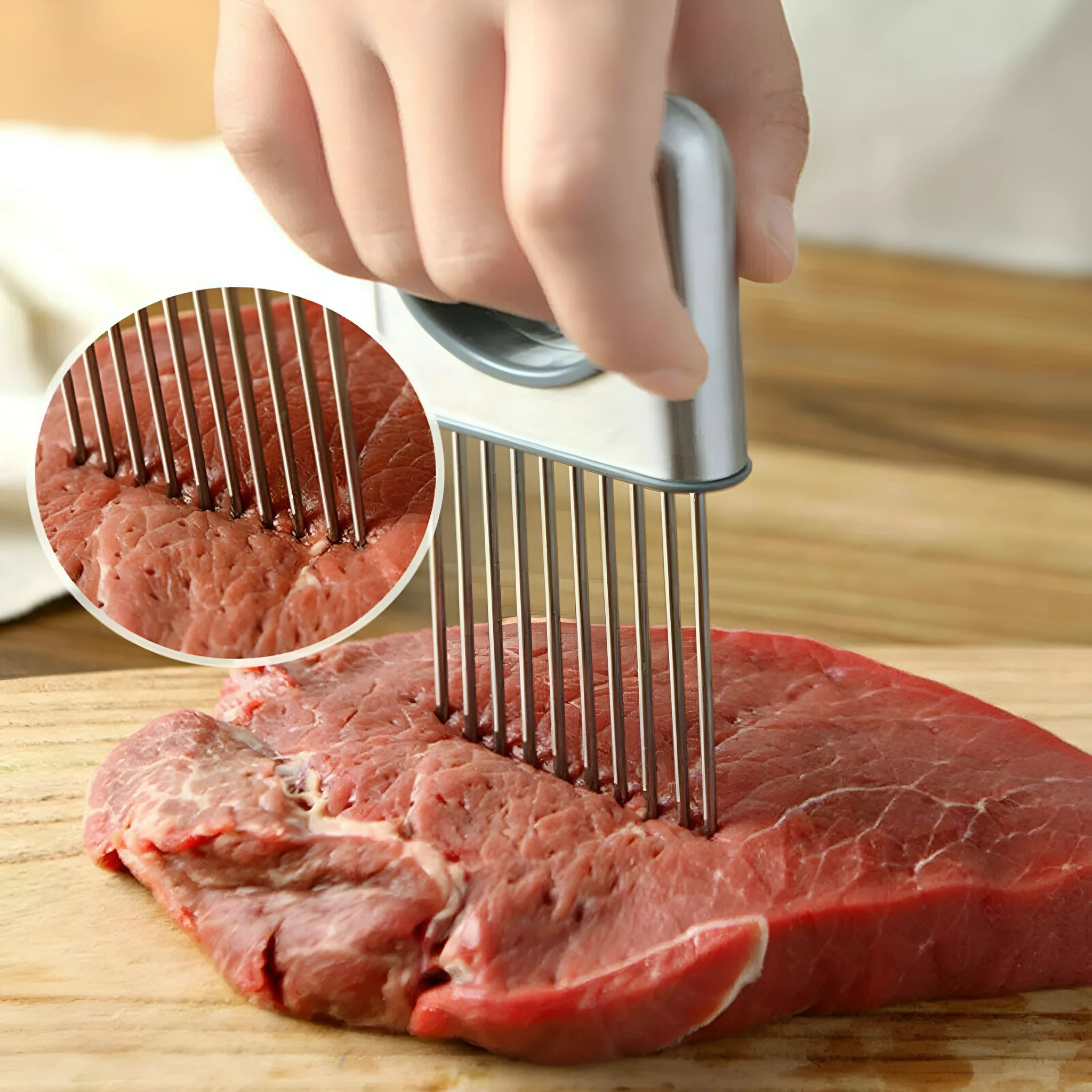 Stainless steel onion holder with sharp prongs and a red finger guard on a kitchen counter.