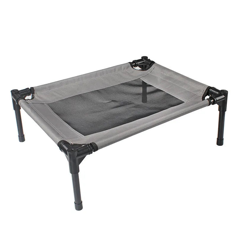 Black Oxford cloth outdoor dog bed with steel frame, shown on grass for camping use.