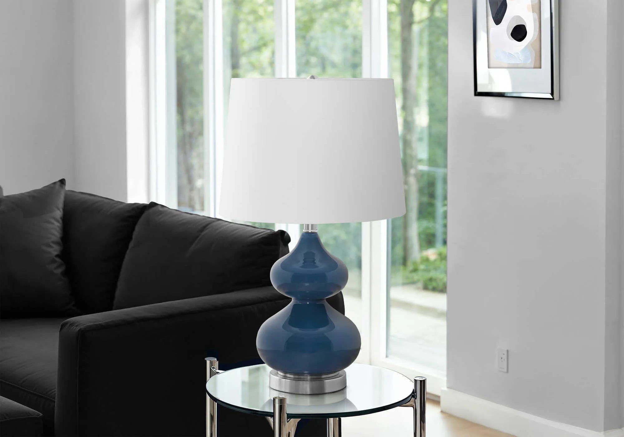 Blue crystal glass desk lamp with white fabric shade on a wooden desk.