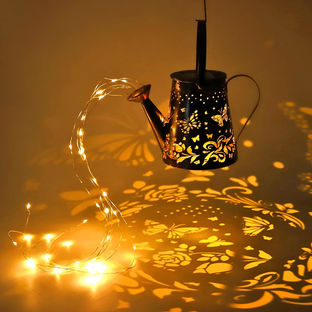 Iron solar garden lamp with a tapered butterfly silhouette emitting warm white light.