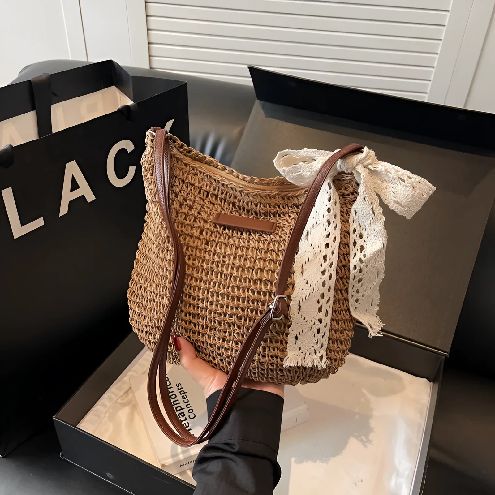 Women's khaki woven straw messenger bag with hollowed pattern and single shoulder strap.