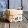 Cement flowerpot with brown paper carton design and drainage hole for indoor balcony plants.