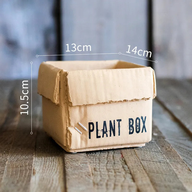 Cement flowerpot with brown paper carton design and drainage hole for indoor balcony plants.