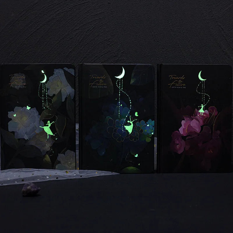 A5 size notebook with a luminous reflective cover, open to show internal pages with colour illustrations.