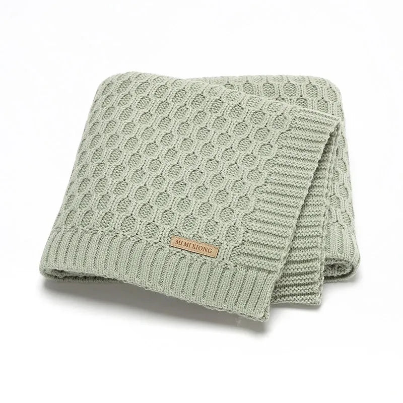 Solid colour baby hug blanket with raised line texture, shown in a light green colour.
