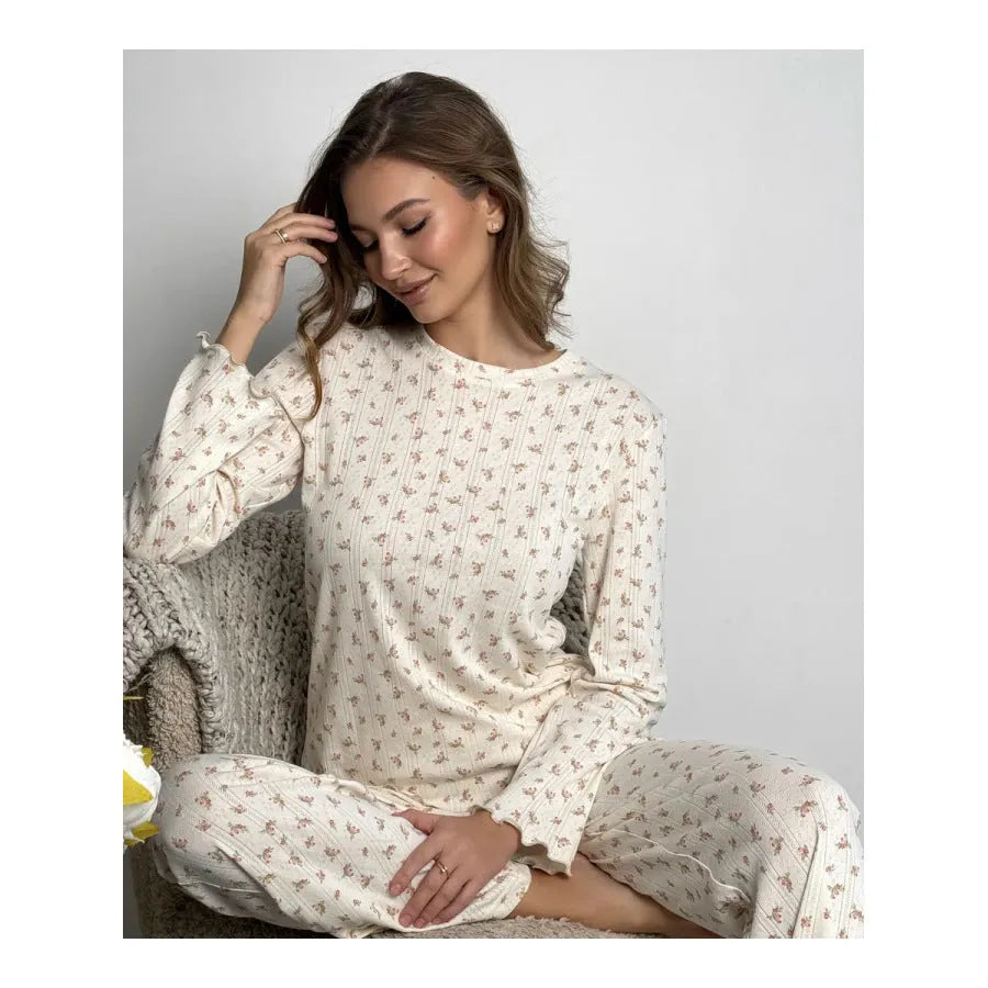 White floral print women's suit with bell sleeve top and wide-leg trousers laid flat