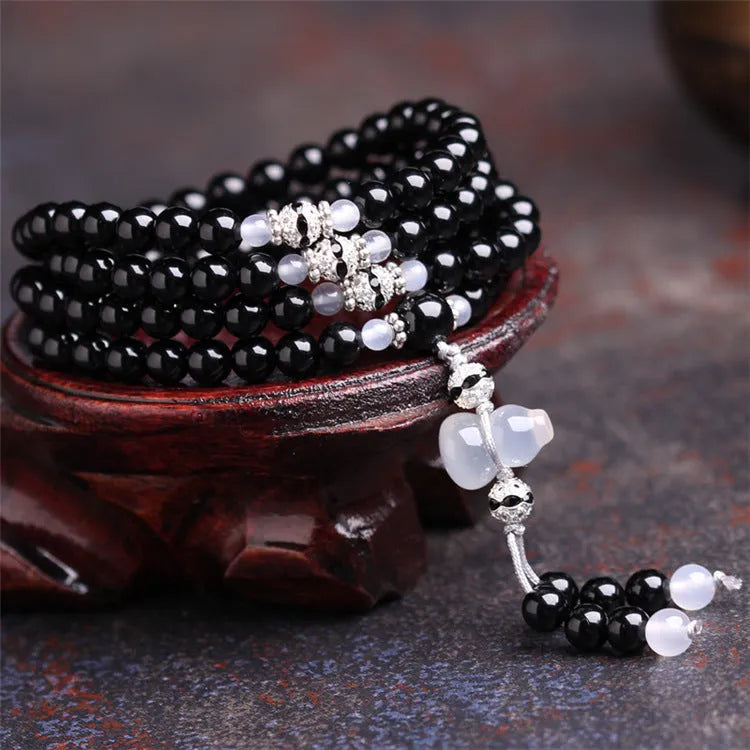 Black agate beaded bracelet with 108 geometric beads and number elements on wrist