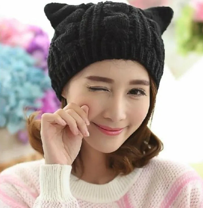 Hand-made red knitted winter beanie with 3D cat ears on a mannequin head.