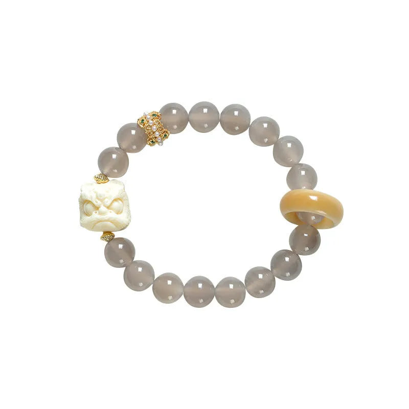 Hand-woven bracelet with 10mm round grey agate and mellite beads on a wrist.