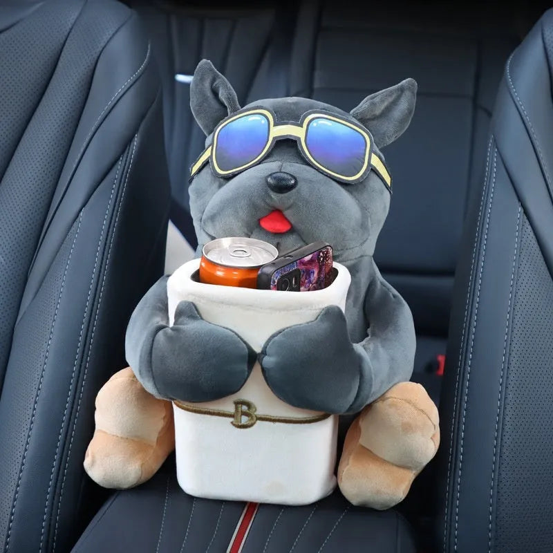 Plush car tissue box holder hanging from flip-down armrest with humorous dog design