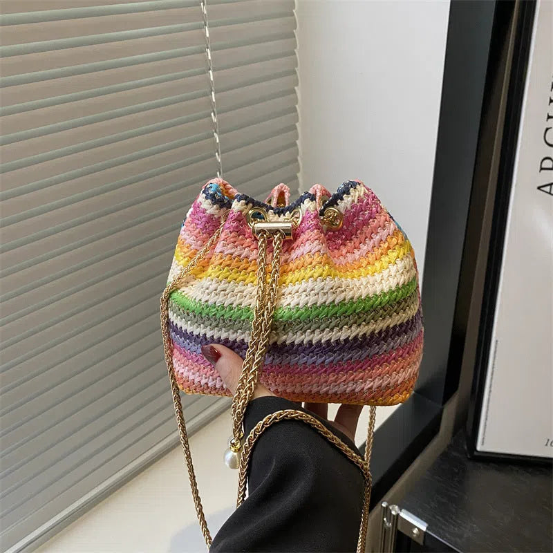 Multicolor straw weave bucket bag with plaid pattern, chain strap, and diamond embellishments