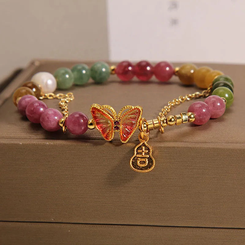 Close-up of a women's agate bracelet with a tourmaline butterfly gourd pendant in natural jade colour.