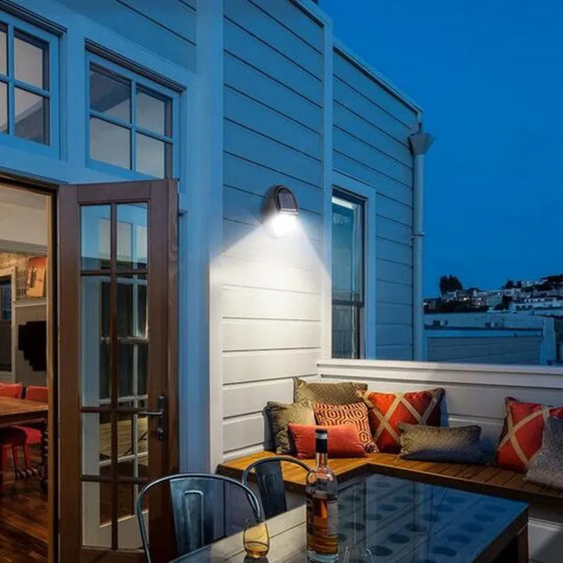 Black rectangular solar-powered LED wall light for outdoor automatic lighting.