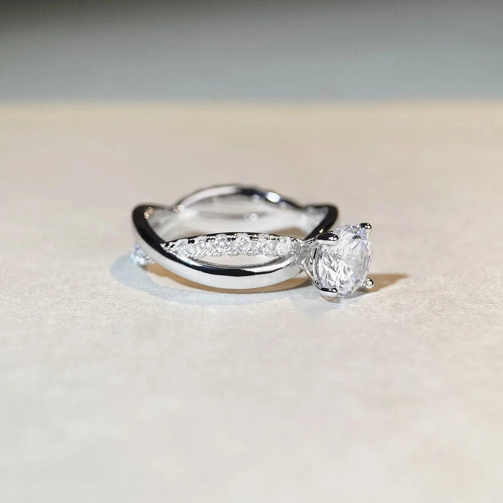 Silver geometric cross ring with a 1 karat moissanite stone in a twisted four-claw setting