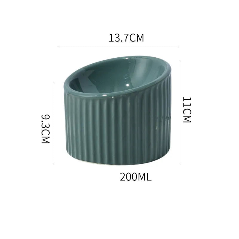Dark green ceramic raised cat bowl with tilted design on a wooden surface.