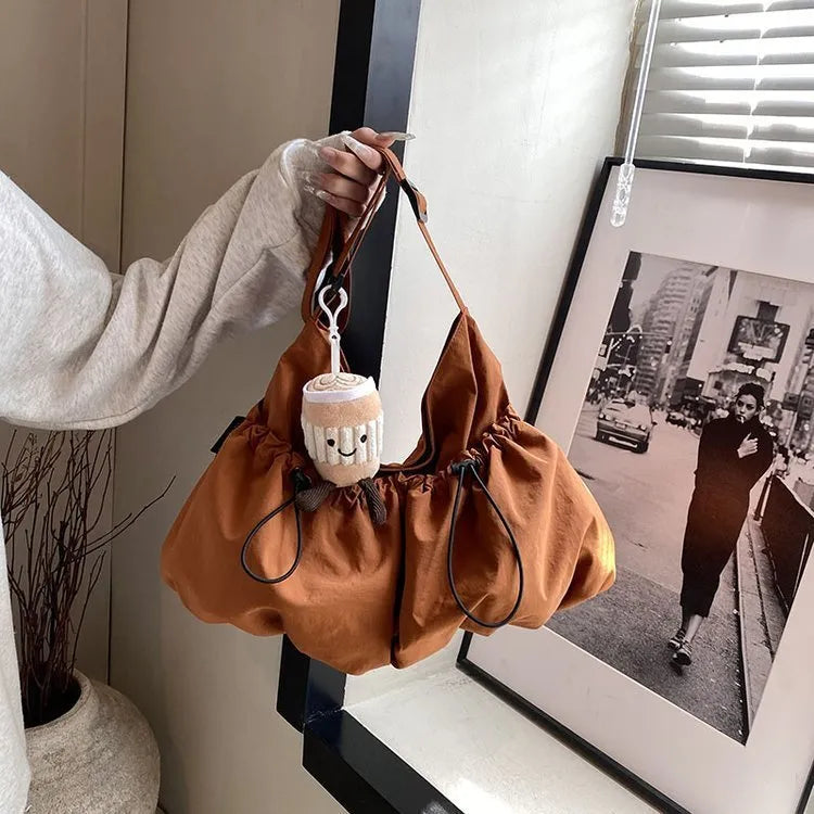 Ultra-light pleated crossbody bag in soft polyester fabric showing split pocket and phone compartment