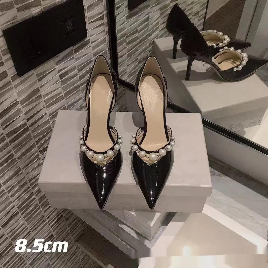 Women's pointed patent leather stiletto high heels with pearl decoration, shown in an oversleeve design.