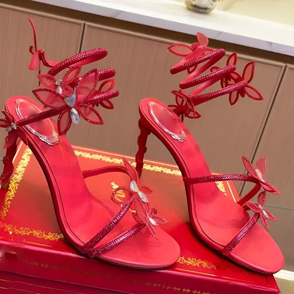 Snake butterfly rhinestone flower stiletto heel Roman sandals in gold with round toe and buckle closure