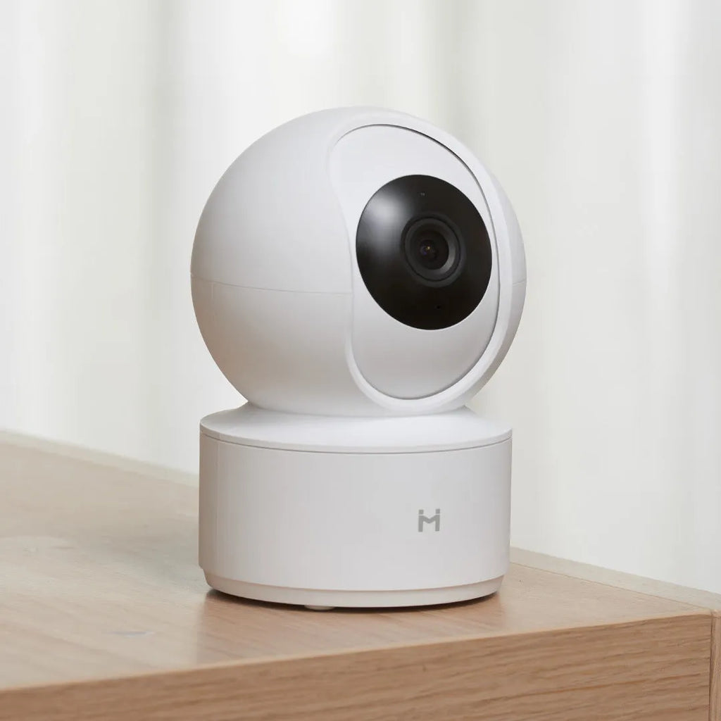 White Xiaobai smart security camera on a surface showing its compact design.