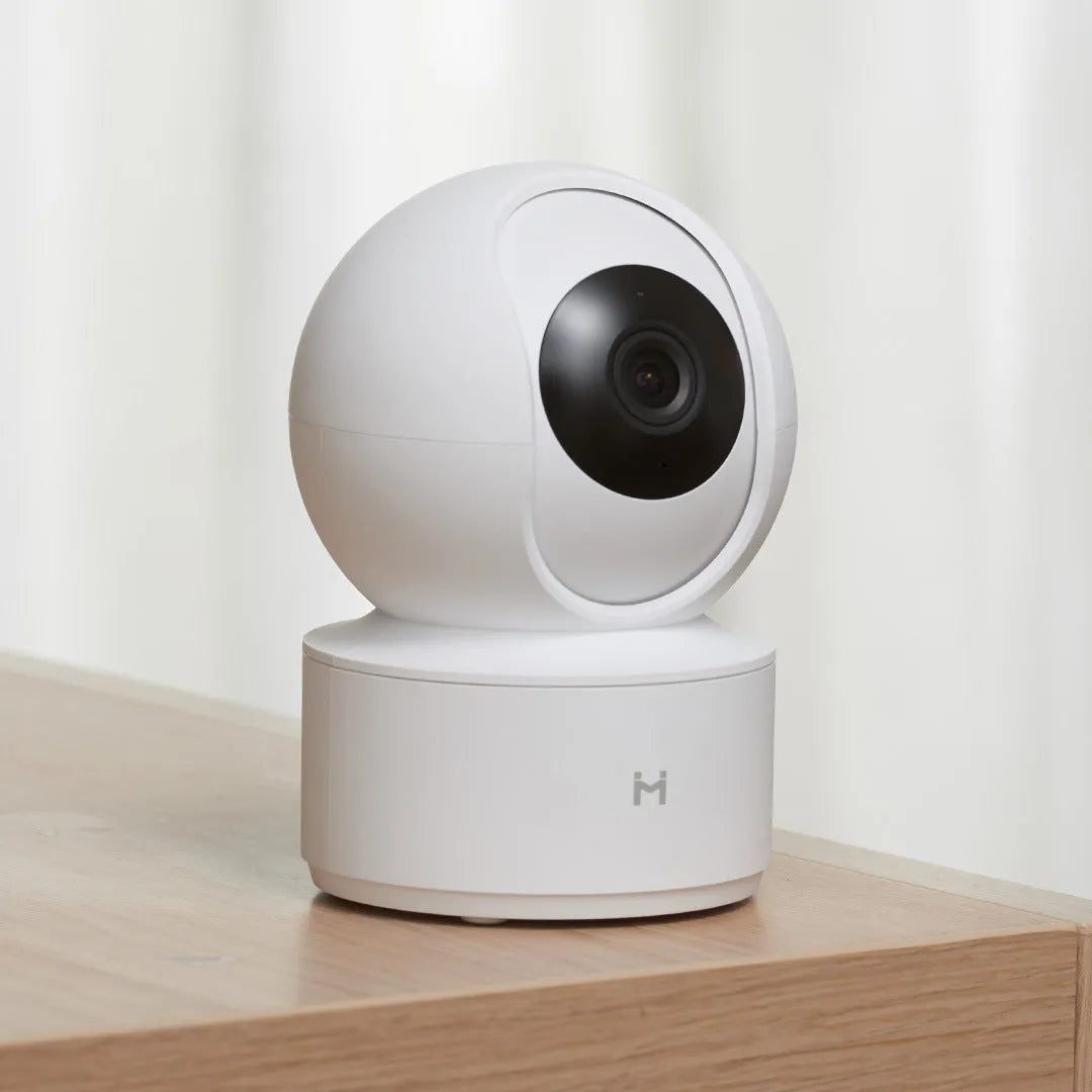 White Xiaobai smart security camera on a surface showing its compact design.