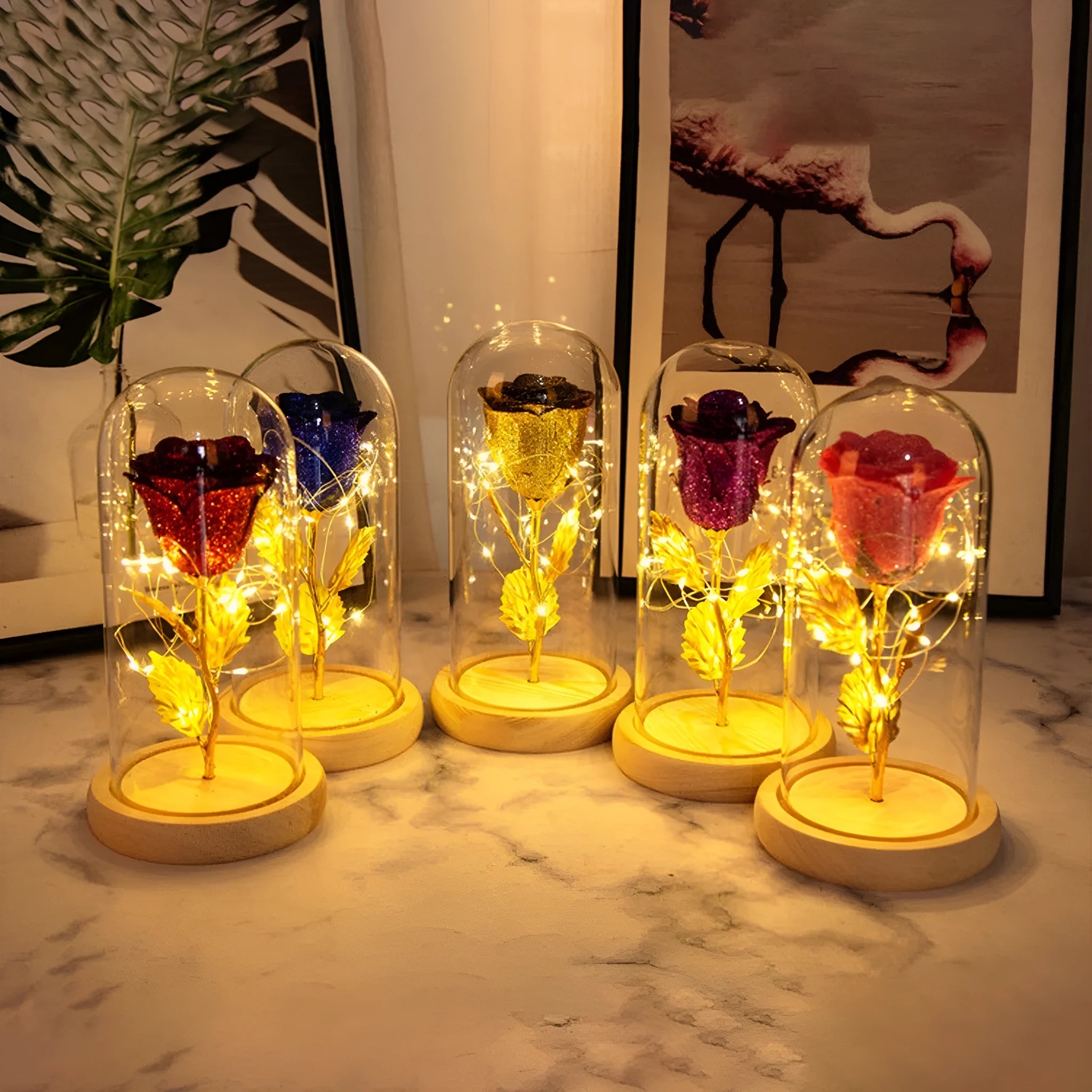 Glass dome containing red eternal roses illuminated by a warm white bendable LED light string.