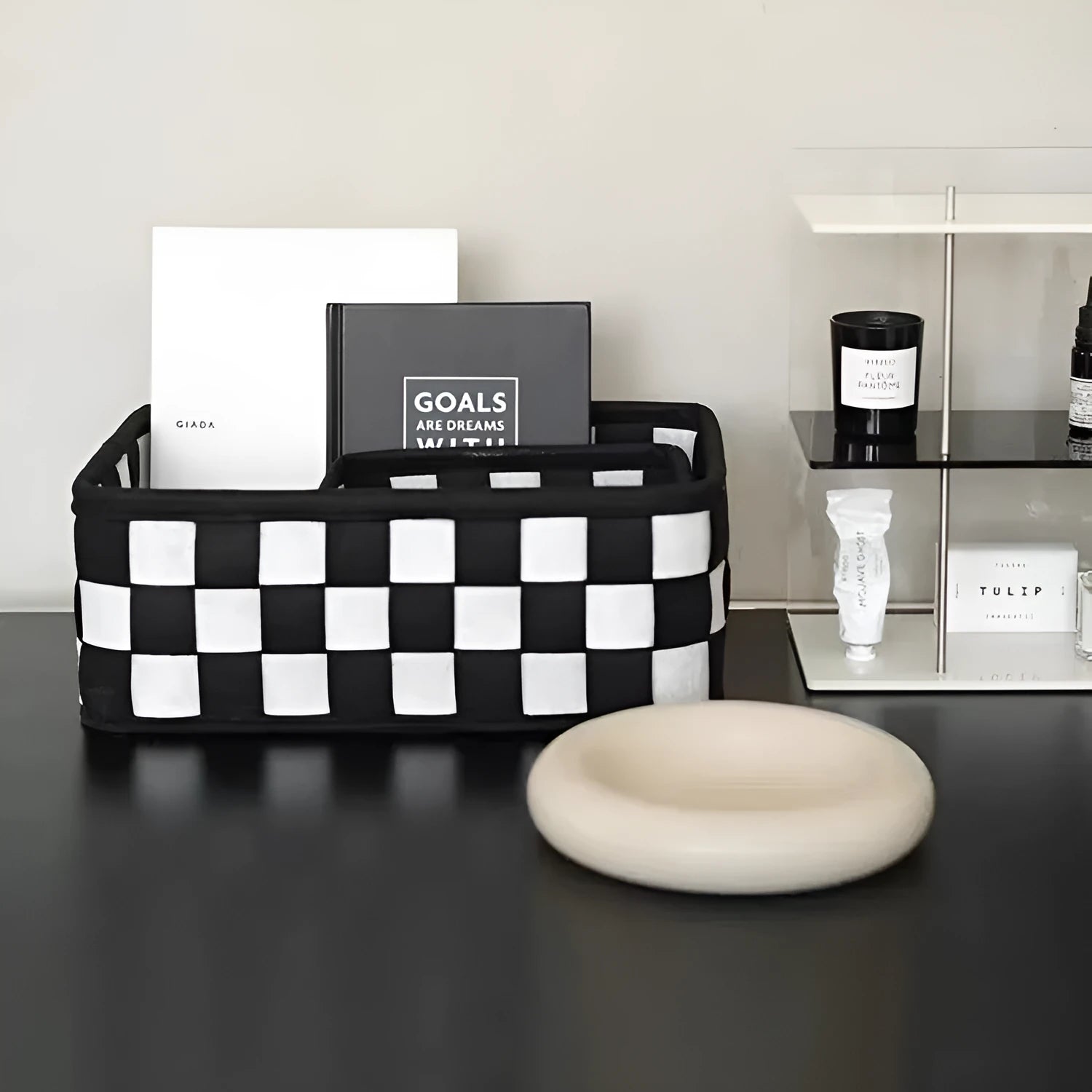 Black and white checkerboard patterned felt folding storage basket shown in its assembled box shape.