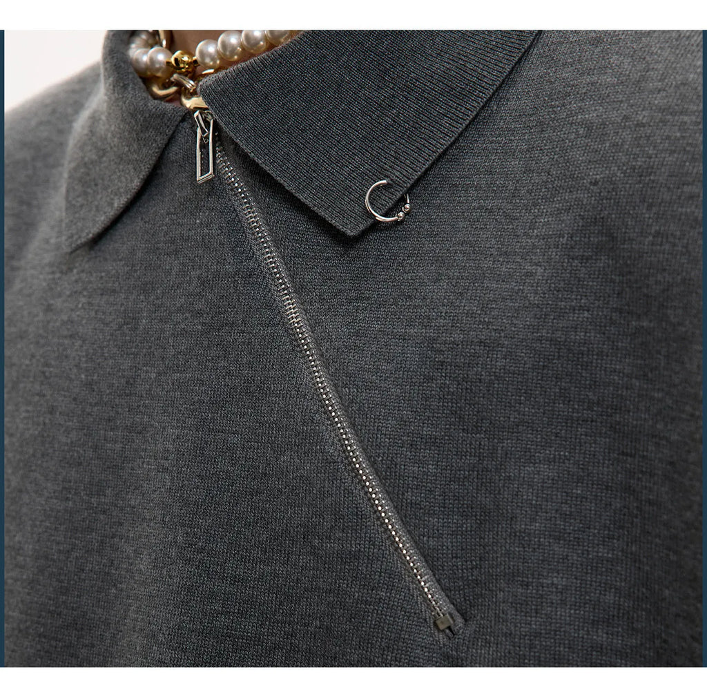 Man wearing a slim-fit black knitted polo shirt with an oblique diagonal zipper and lapel collar.