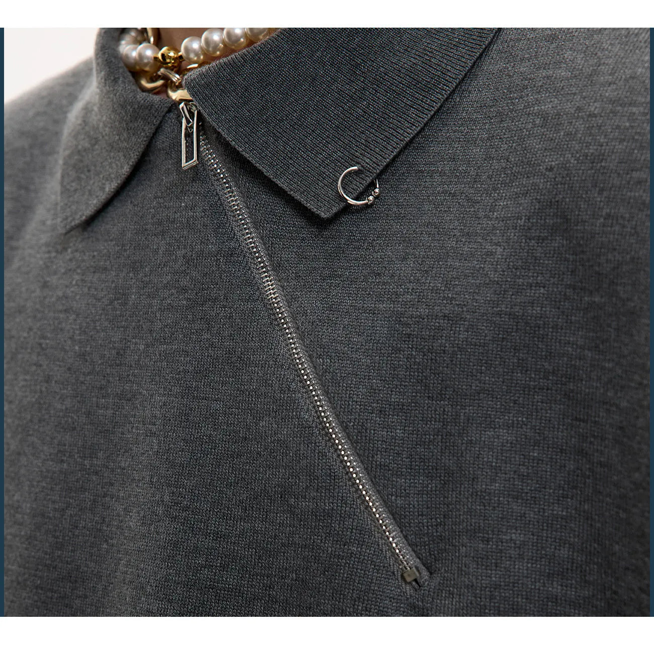 Man wearing a slim-fit black knitted polo shirt with an oblique diagonal zipper and lapel collar.