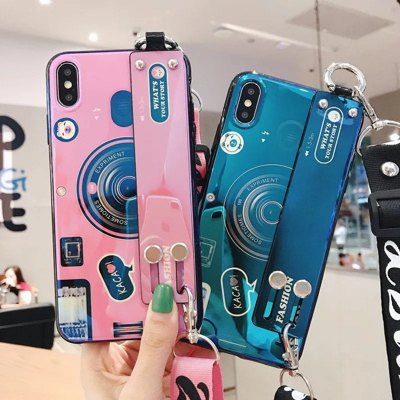 TPU iPhone case with retro camera design in blue or pink, back cover style, optional wrist strap.