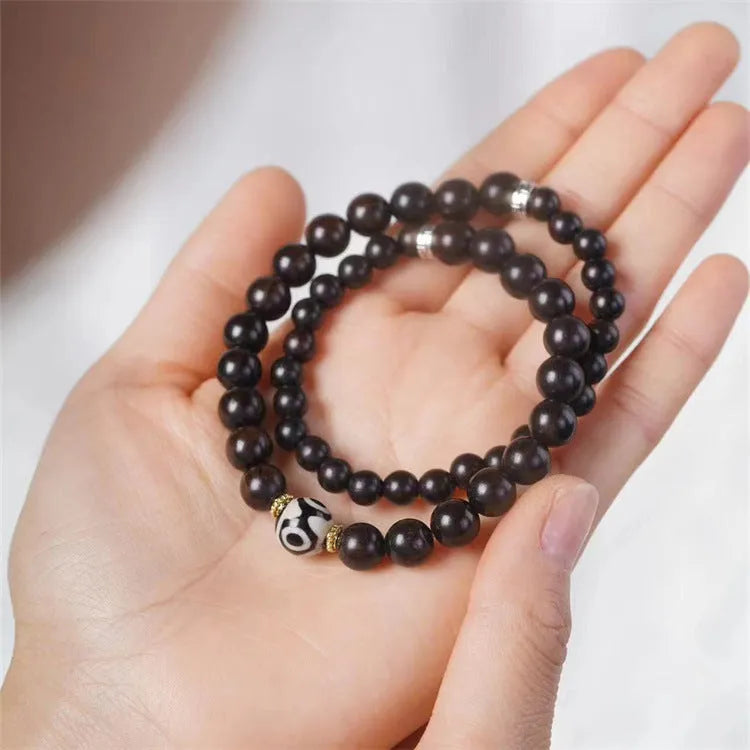Dark ebony wood bracelet with 8mm Tibet-style beads and circle elements on wrist