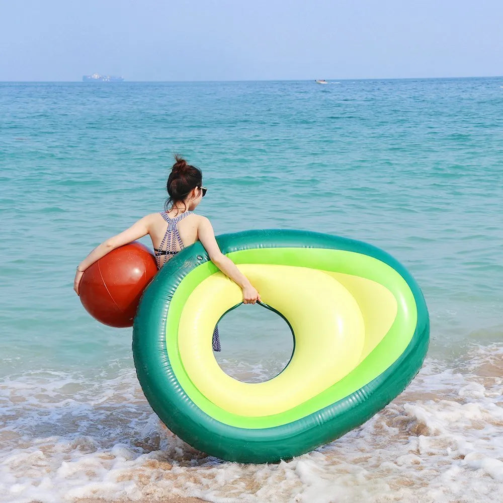 Large green inflatable avocado pool float on blue water, showing its 169cm length.